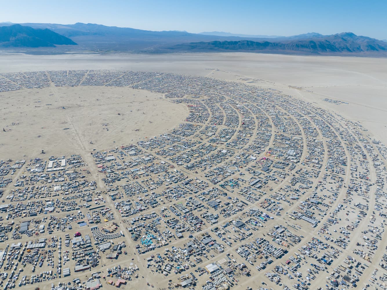 Black Rock City from the air, the street arc and the radial avenues laid out around the open playa.